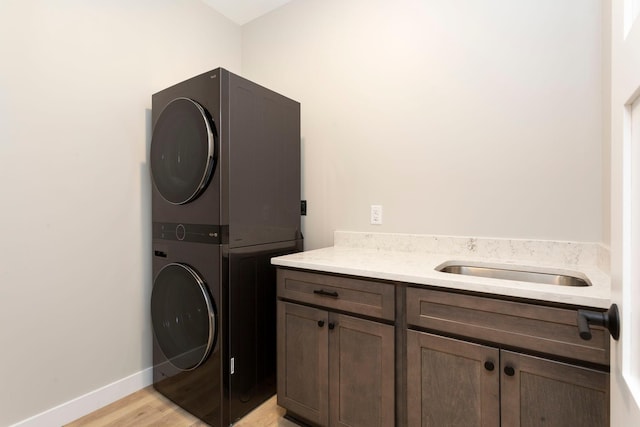 415 Moelter Ln, Troy Twp, WI 54016 - washroom with estacked washer and dryer, cabinet space, light wood-style floors, and baseboards