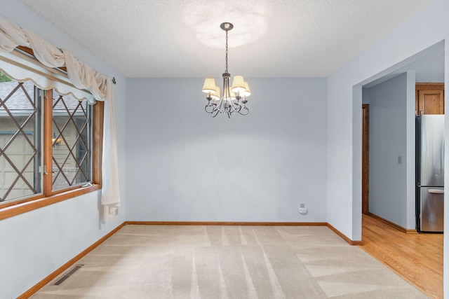 1527 Clarendon Dr, Minnetonka, MN 55391 - unfurnished dining area featuring a chandelier, a textured ceiling, and light colored carpet