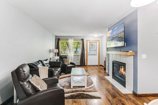10938 181st Ln NW, Elk River, MN 55330 - living room with a fireplace, a textured ceiling, wood finished floors, and baseboards
