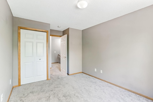 10938 181st Ln NW, Elk River, MN 55330 - unfurnished bedroom with carpet floors, a closet, baseboards, and a textured ceiling