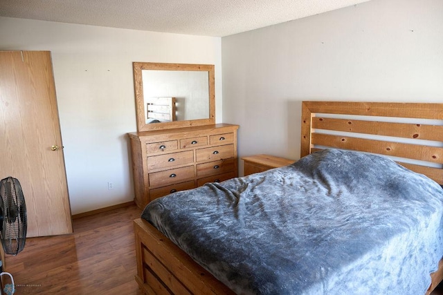 bedroom featuring wood finished floors and baseboards