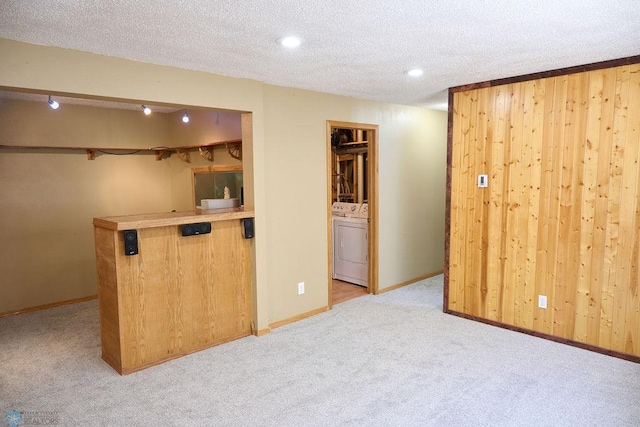 bar area featuring washer / clothes dryer, light colored carpet, a textured ceiling, recessed lighting, and baseboards