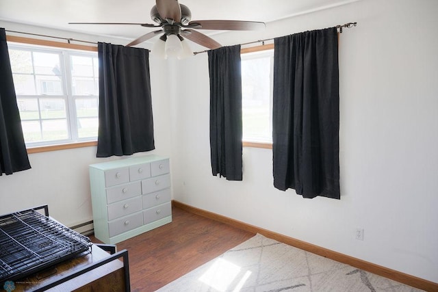 bedroom featuring baseboards, wood finished floors, and ceiling fan