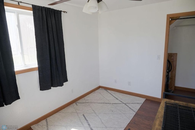 spare room featuring ceiling fan, baseboards, and light wood-type flooring