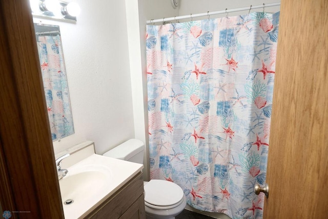 bathroom with toilet, vanity, and a shower with shower curtain