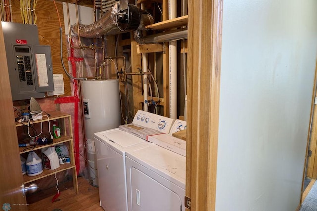 laundry area with electric panel, water heater, washer and clothes dryer, and wood finished floors