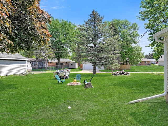 550 Center St, Tracy, MN 56175 - view of green lawn featuring an outdoor fire pit and an outdoor structure