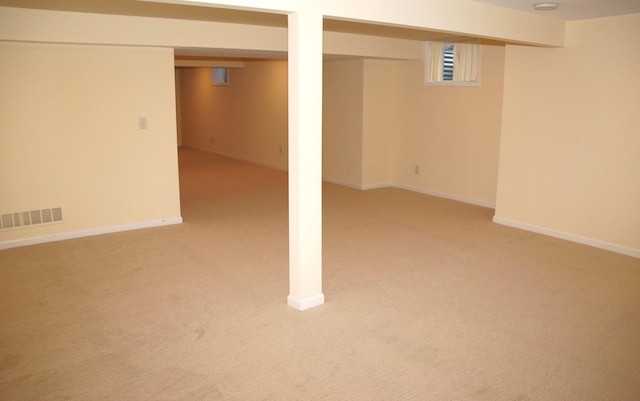 finished basement with light colored carpet and baseboards
