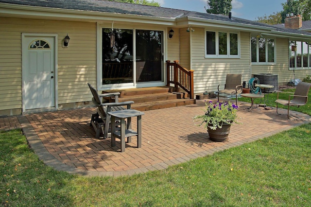 rear view of house featuring entry steps, central AC, a patio, and a chimney