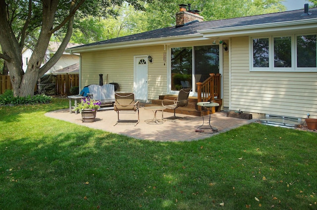 back of property with a chimney and a patio