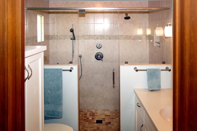 full bathroom featuring vanity, a stall shower, and toilet