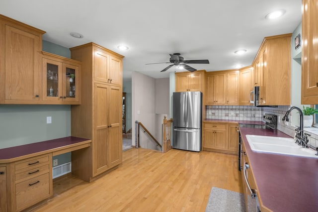 7712 Bester Ave, Inver Grove Heights, MN 55076 - kitchen featuring appliances with stainless steel finishes, a sink, tasteful backsplash, light wood finished floors, and ceiling fan
