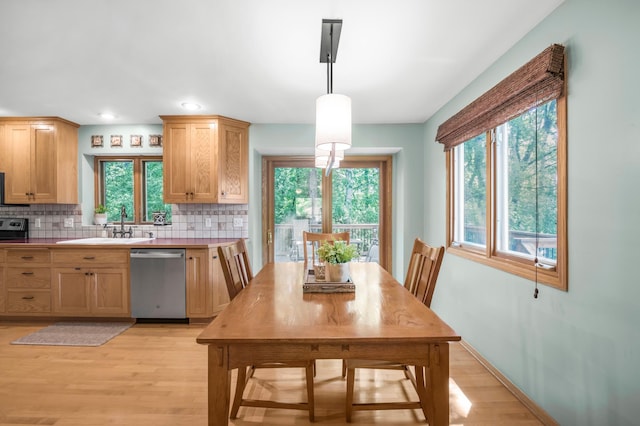 7712 Bester Ave, Inver Grove Heights, MN 55076 - kitchen featuring stainless steel dishwasher, decorative backsplash, light wood finished floors, light countertops, and a sink