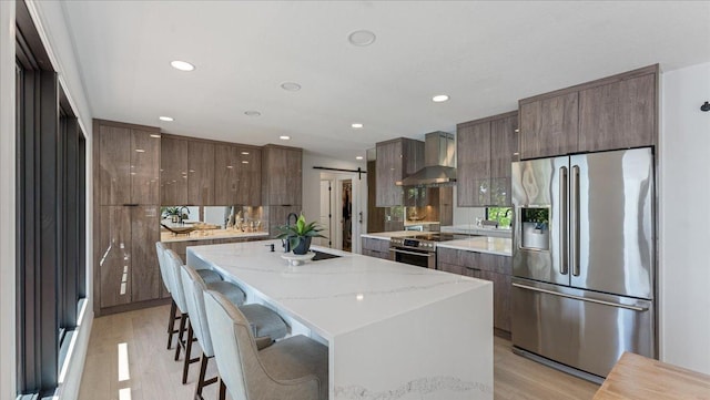 1219 Latoka Dr SW, Alexandria, MN 56308 - kitchen featuring appliances with stainless steel finishes, wall chimney exhaust hood, modern cabinets, light wood-type flooring, and recessed lighting