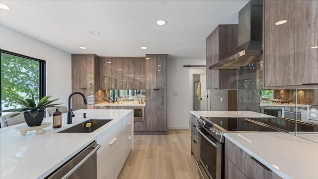 1219 Latoka Dr SW, Alexandria, MN 56308 - kitchen featuring modern cabinets, wall chimney range hood, appliances with stainless steel finishes, a sink, and recessed lighting