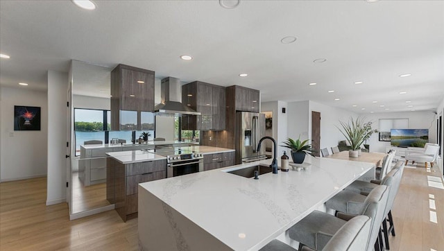 1219 Latoka Dr SW, Alexandria, MN 56308 - kitchen with wall chimney exhaust hood, modern cabinets, stainless steel appliances, a large island, and recessed lighting
