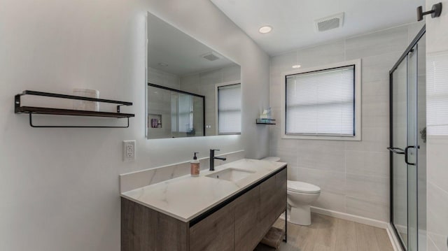 1219 Latoka Dr SW, Alexandria, MN 56308 - bathroom with vanity, toilet, a shower stall, and wood finished floors