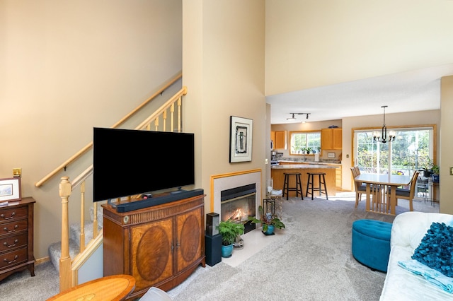8766 Benson Way Unit 84, Inver Grove Heights, MN 55076 - living room featuring stairway, light colored carpet, a high ceiling, a chandelier, and a fireplace with flush hearth