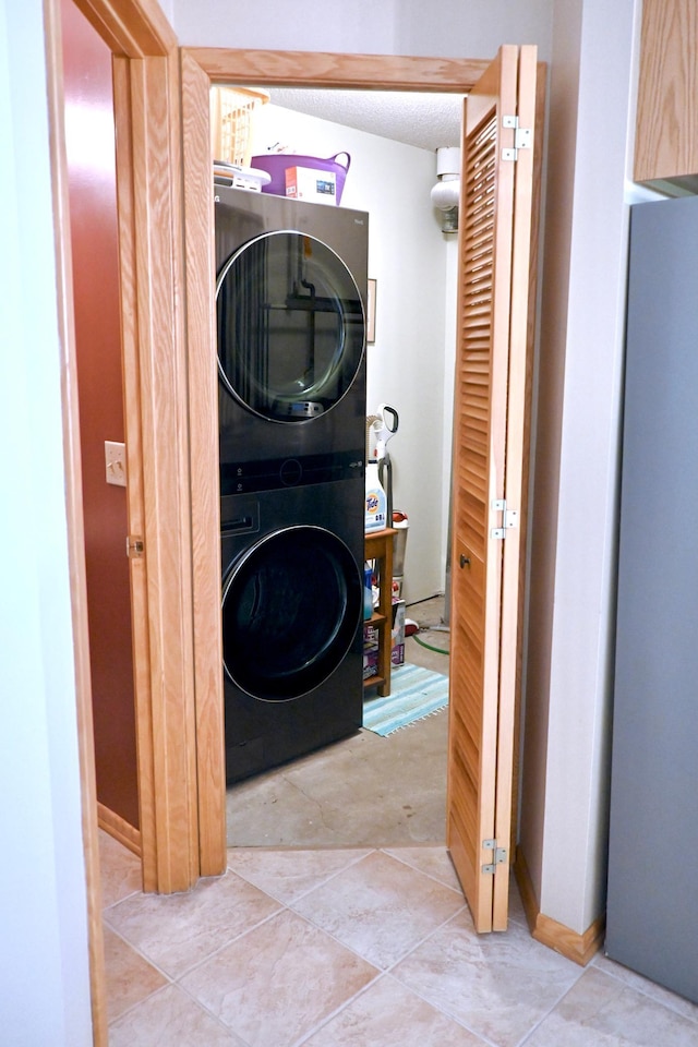 8766 Benson Way Unit 84, Inver Grove Heights, MN 55076 - clothes washing area with stacked washing machine and dryer, a textured ceiling, and tile patterned flooring