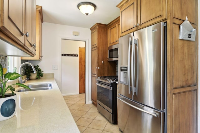 5240 Birch Rd, Minnetonka, MN 55345 - kitchen featuring stainless steel appliances, a sink, light countertops, light tile patterned flooring, and brown cabinets