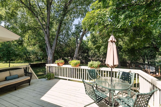 5240 Birch Rd, Minnetonka, MN 55345 - wooden terrace with outdoor dining space, a fenced backyard, view of wooded area, and an outdoor living space