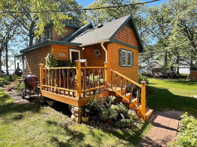 23979 Navajo Trl, Henning, MN 56551 - view of side of home featuring a shingled roof, a lawn, and a deck