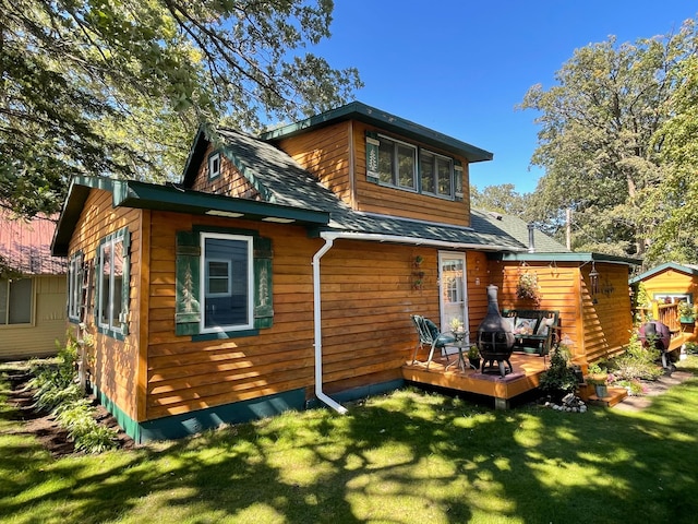 23979 Navajo Trl, Henning, MN 56551 - back of property featuring a wooden deck, a lawn, and a shingled roof