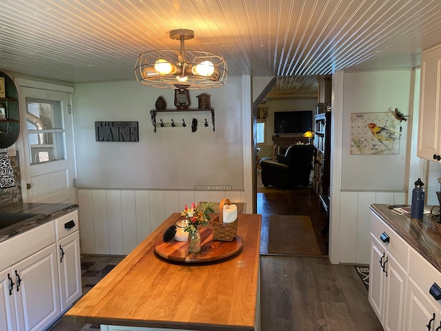 23979 Navajo Trl, Henning, MN 56551 - dining space featuring wainscoting, wooden ceiling, dark wood-type flooring, and a chandelier