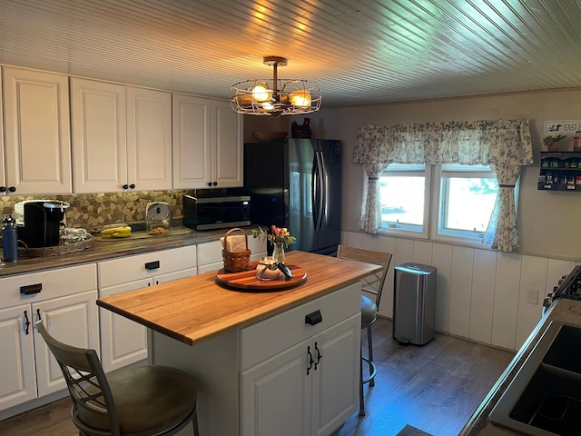 23979 Navajo Trl, Henning, MN 56551 - kitchen featuring stainless steel microwave, freestanding refrigerator, butcher block countertops, white cabinets, and a chandelier