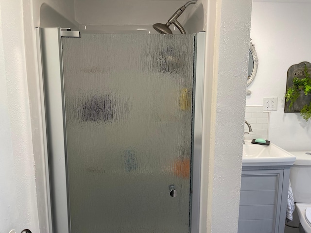23979 Navajo Trl, Henning, MN 56551 - bathroom featuring toilet, a shower stall, vanity, and backsplash