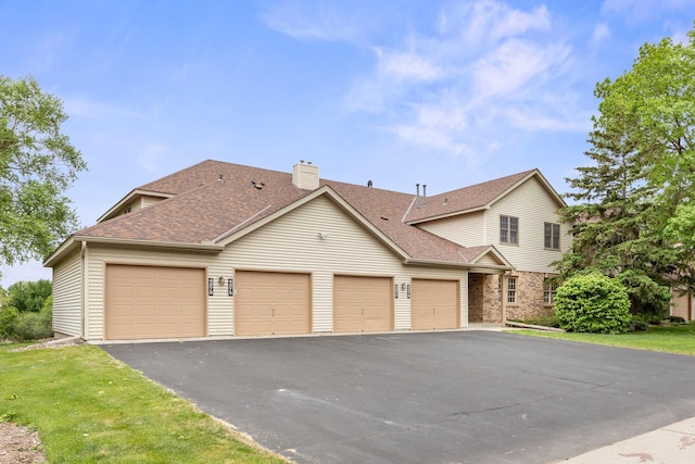 4277 Oakmede Ln Unit 62C, White Bear Twp, MN 55110 - view of front of property featuring a chimney, a shingled roof, driveway, and a garage