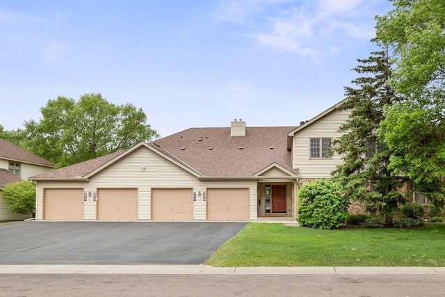 4277 Oakmede Ln Unit 62C, White Bear Twp, MN 55110 - view of front of property featuring a front lawn, a shingled roof, a chimney, and asphalt driveway