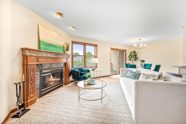 4277 Oakmede Ln Unit 62C, White Bear Twp, MN 55110 - living area featuring a high end fireplace, a chandelier, light wood-type flooring, and baseboards
