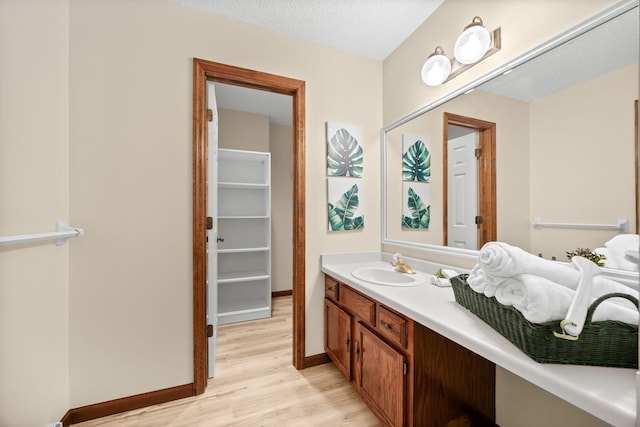 4277 Oakmede Ln Unit 62C, White Bear Twp, MN 55110 - bathroom featuring wood finished floors, vanity, and baseboards
