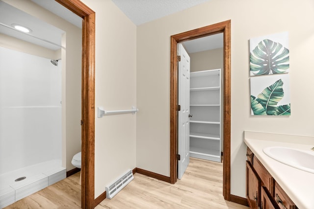 4277 Oakmede Ln Unit 62C, White Bear Twp, MN 55110 - full bath featuring wood finished floors, a shower stall, vanity, and toilet