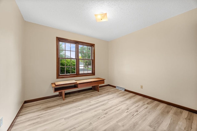 4277 Oakmede Ln Unit 62C, White Bear Twp, MN 55110 - empty room with light wood-style flooring, baseboards, and a textured ceiling