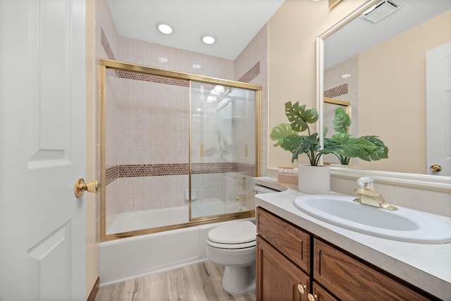 4277 Oakmede Ln Unit 62C, White Bear Twp, MN 55110 - full bathroom with toilet, vanity, wood finished floors, enclosed tub / shower combo, and a textured ceiling