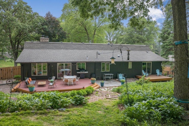 4744 Westgate Rd, Minnetonka, MN 55345 - rear view of house with roof with shingles, a chimney, a wooden deck, and board and batten siding