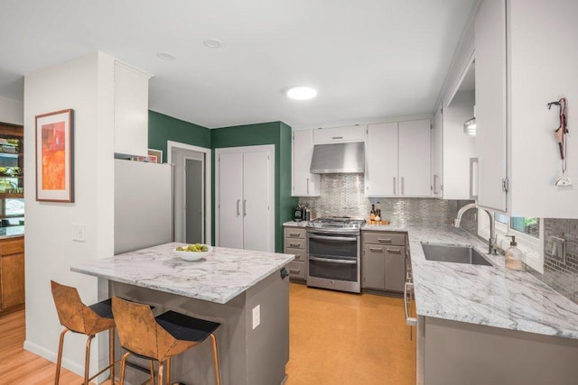 4744 Westgate Rd, Minnetonka, MN 55345 - kitchen featuring range with two ovens, ventilation hood, freestanding refrigerator, and decorative backsplash