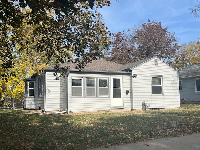 view of front of home featuring a front yard and roof with shingles