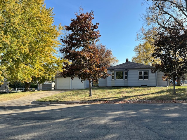 view of front of house featuring a garage, a front lawn, driveway, and a chimney