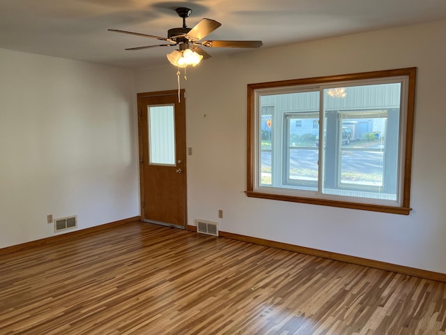spare room with wood finished floors, baseboards, and a ceiling fan