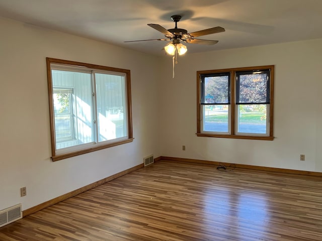 empty room featuring wood finished floors, plenty of natural light, and ceiling fan