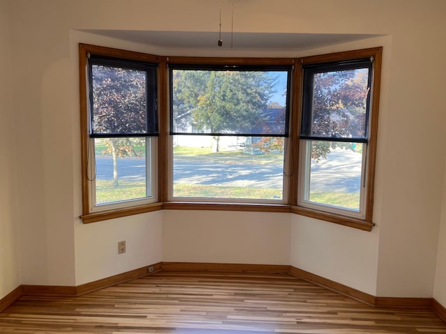 unfurnished dining area with light wood-style floors and baseboards