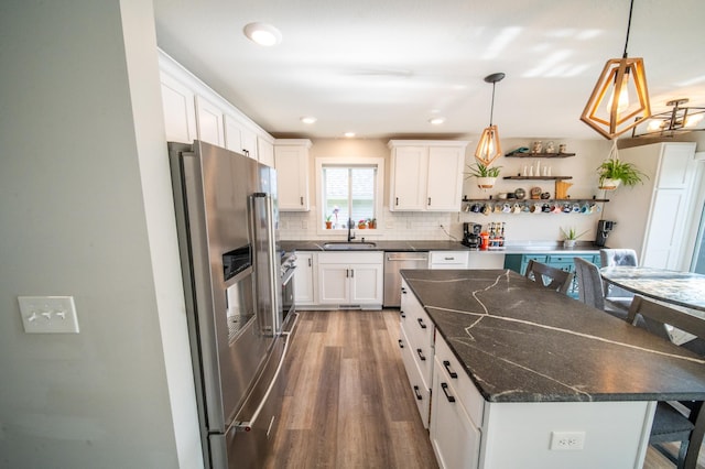 1004 Blanch Ct, Mantorville, MN 55955 - kitchen with appliances with stainless steel finishes, a sink, wood finished floors, a kitchen island, and white cabinets