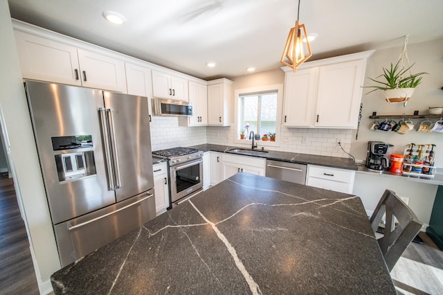 1004 Blanch Ct, Mantorville, MN 55955 - kitchen with high end appliances, a sink, tasteful backsplash, hanging light fixtures, and white cabinets