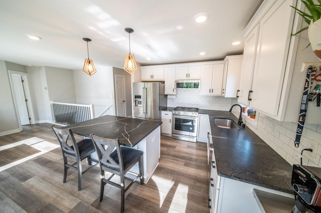 1004 Blanch Ct, Mantorville, MN 55955 - kitchen featuring a sink, stainless steel appliances, dark wood-style floors, tasteful backsplash, and white cabinets