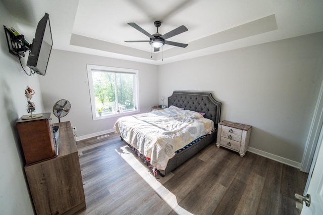 1004 Blanch Ct, Mantorville, MN 55955 - bedroom featuring a raised ceiling, baseboards, dark wood-style floors, and a ceiling fan