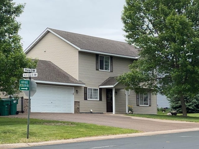 1200 Prairie St NW, Montgomery, MN 56069 - view of front facade with asphalt driveway, a shingled roof, a garage, and a front lawn