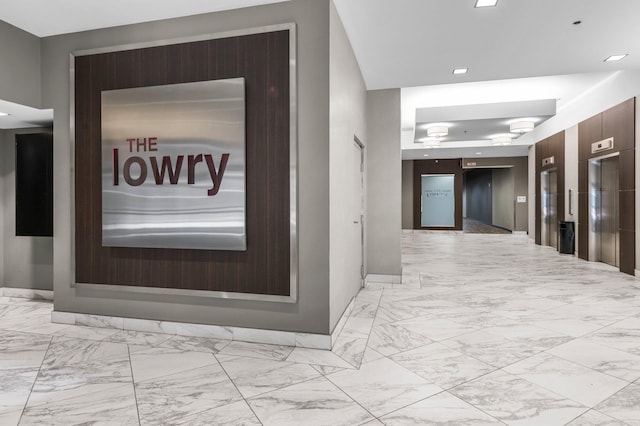 350 Saint Peter St Unit 701, Saint Paul, MN 55102 - hallway with light marble finish flooring, elevator, and baseboards